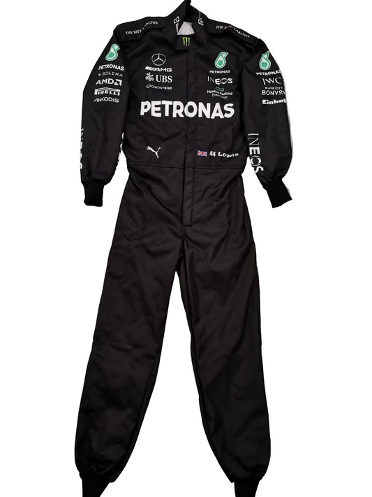 A black Mercedes Petronas racing one-piece suit with various sponsor logos, laid flat on a gray marble-patterned tile floor.